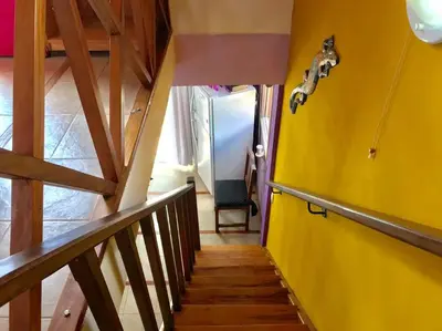 a hallway with a yellow wall and stairs with a door at CABAÑA LA MILAGROS REINA MORA in Merlo