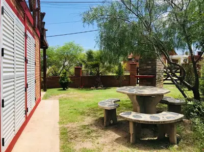 a picnic table and two benches in a yard at CABAÑA LA MILAGROS REINA MORA in Merlo