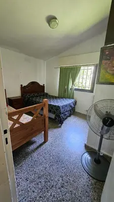 a bedroom with a bed and a window with a fan at LUSANYUN in Villa Carlos Paz