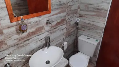 a bathroom with a white toilet and a sink at LUSANYUN in Villa Carlos Paz