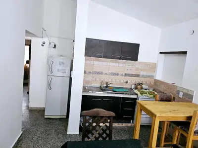 a kitchen with a white refrigerator and a table at LUSANYUN in Villa Carlos Paz