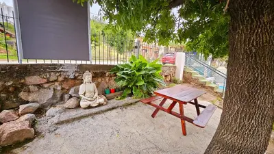 a picnic table and a statue next to a tree at LUSANYUN in Villa Carlos Paz