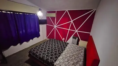 a bedroom with a bed with a red and purple wall at LUSANYUN in Villa Carlos Paz