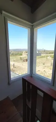 two windows in a room with a view of a field at Cabaña Nerviomotor in Cordoba