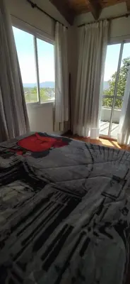 a bedroom with a large bed with windows at Cabaña Nerviomotor in Cordoba