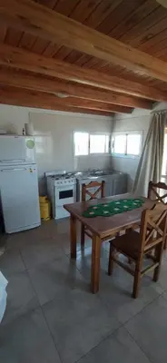 a kitchen with a wooden table and chairs and a stove at Cabaña Nerviomotor in Cordoba