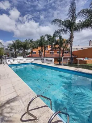 a swimming pool at a resort with palm trees at Saint Tropez Hotel in Villa Carlos Paz