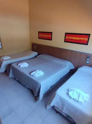 two beds in a hotel room with towels on them at Saint Tropez Hotel in Villa Carlos Paz