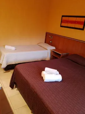 two beds in a hotel room with towels on them at Saint Tropez Hotel in Villa Carlos Paz