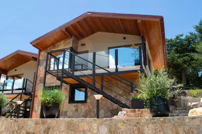 a modern house with a stone wall at Vimaen Suites in La Cumbrecita