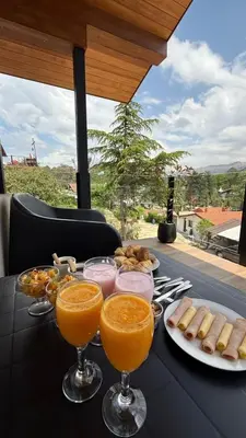 a black table with glasses of orange juice and snacks at Vimaen Suites in La Cumbrecita