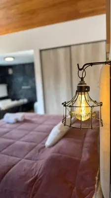 a lamp sitting on the side of a bed at Vimaen Suites in La Cumbrecita