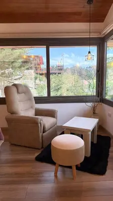 a living room with a chair and a coffee table at Vimaen Suites in La Cumbrecita