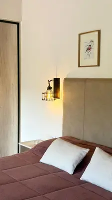 a bedroom with a bed and a chandelier at Vimaen Suites in La Cumbrecita