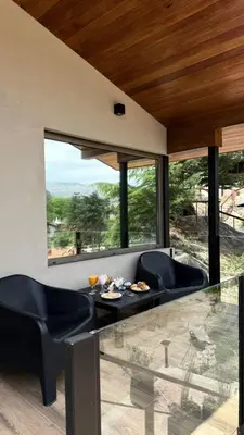 a living room with a glass table and chairs at Vimaen Suites in La Cumbrecita