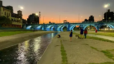 a group of people walking their dogs next to a river at Encantador Duplex cerca de todo in Cordoba