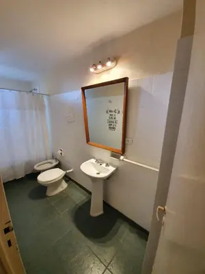 a bathroom with a toilet and a sink and a mirror at Dpto Cordoba Capital in Cordoba