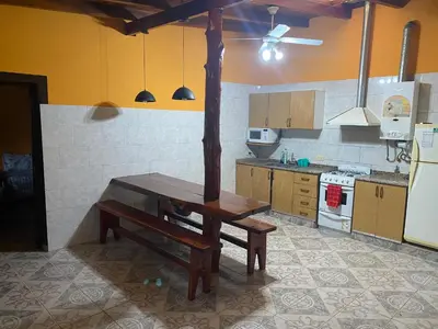 a kitchen with a wooden table in the middle at Cabaña Emilia in San Javier