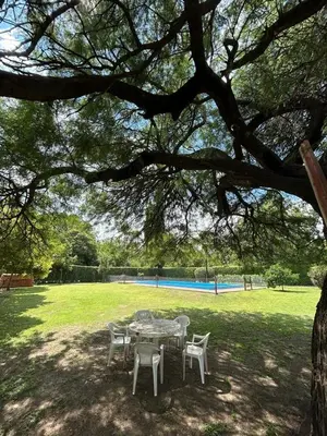 a table and chairs under a tree in a park at Cabaña Emilia in San Javier