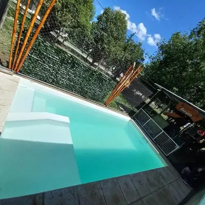 a large blue swimming pool with a fence at HARD ROCK SERRANO in Santa María