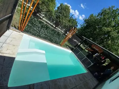 a large blue swimming pool in a yard at HARD ROCK SERRANO in Santa María