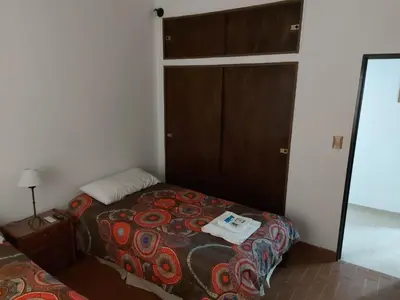 a small bedroom with a bed and a mirror at Aire Serrano in Alta Gracia