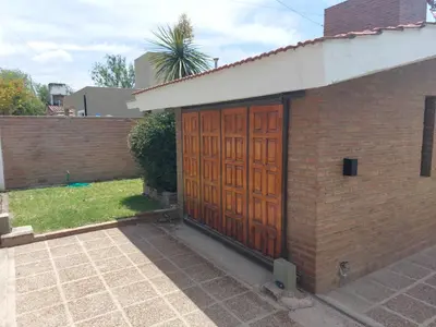a brick building with a pair of wooden doors at Aire Serrano in Alta Gracia