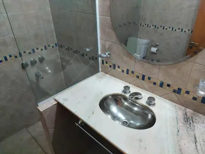 a bathroom with a sink and a shower with a mirror at Aire Serrano in Alta Gracia
