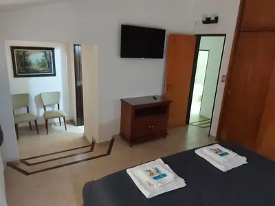 a room with a bed and a mirror and a tv at Aire Serrano in Alta Gracia