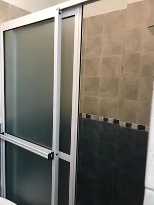 a sliding glass shower door in a bathroom at Departamento céntrico Villa Carlos Paz in Villa Carlos Paz
