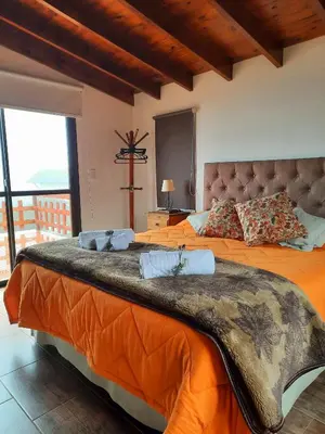 a bedroom with two beds with orange sheets at MiraSierras -casas vacacionales- in Villa General Belgrano