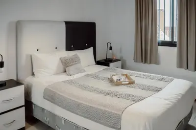 a bedroom with a large white bed with a tray on it at Departamento en calle Paraná by Lofty in Cordoba