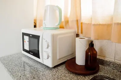 a microwave on a counter with a jug on top at Departamento en calle Paraná by Lofty in Cordoba