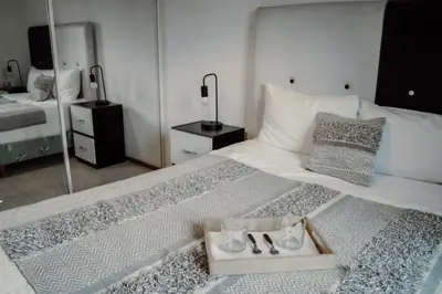 a bedroom with a white bed with a tray of shoes at Departamento en calle Paraná by Lofty in Cordoba