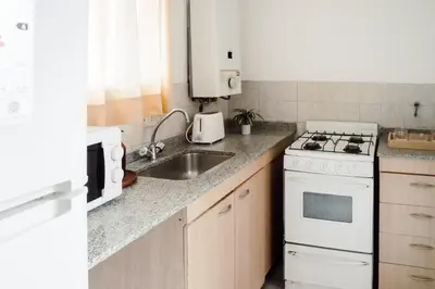 a kitchen with a white stove and a sink at Departamento en calle Paraná by Lofty in Cordoba