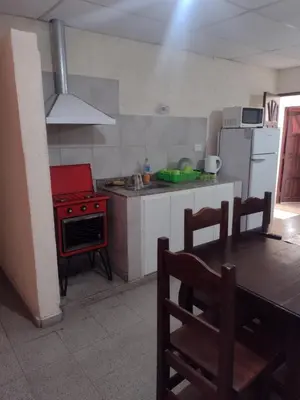 a kitchen with a table and a red stove top oven at Complejo de Departamentos DON QUIJOTE in Almafuerte