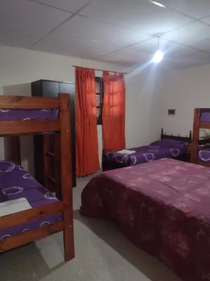a room with two beds and two bunk beds at Complejo de Departamentos DON QUIJOTE in Almafuerte