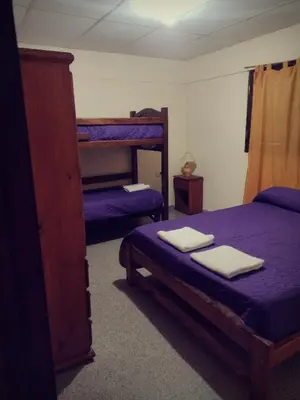 a bedroom with two bunk beds with purple sheets at Complejo de Departamentos DON QUIJOTE in Almafuerte