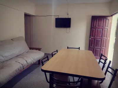 a living room with a table and a couch at Complejo de Departamentos DON QUIJOTE in Almafuerte