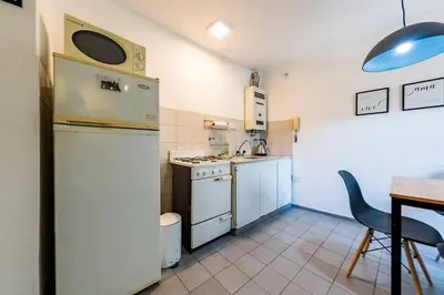 a small kitchen with a white refrigerator and a table at Marcelo T de Alvear 628 - B Güemes con Vistas a la Cañada in Cordoba