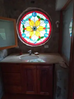 a bathroom with a sink and a stained glass window at Casa Desconectar in Villa Berna