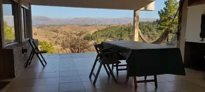 a table and chairs on a balcony with a view at Casa Desconectar in Villa Berna