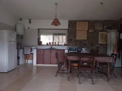 a kitchen with a table and chairs and a refrigerator at Casa Desconectar in Villa Berna