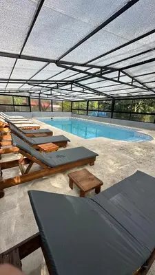 a large swimming pool with tables and chairs in a building at Apart Hotel Nonquen in Merlo