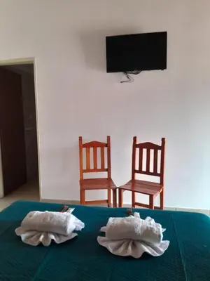two towels sitting on a bed with two chairs at Apart Hotel Nonquen in Merlo