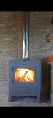 a oven with a fire inside of it at La Calma, casa frente al río, gran parque y pileta in Villa Icho Cruz