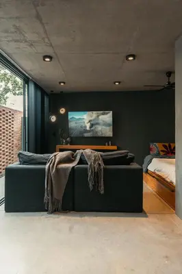 a living room with a green couch and a bed at Loft 1930 in Villa Carlos Paz