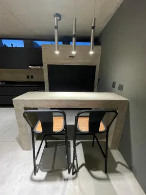 a kitchen with a table with two black chairs at Loft 1930 in Villa Carlos Paz