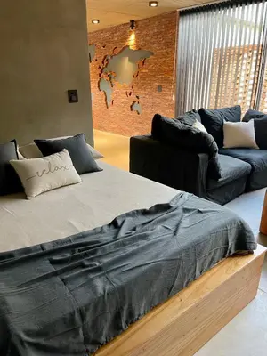 a bedroom with a large bed and a couch at Loft 1930 in Villa Carlos Paz