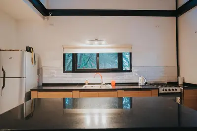 a kitchen with a sink and a refrigerator at Casa Brunia Lago Los Molinos in Villa General Belgrano